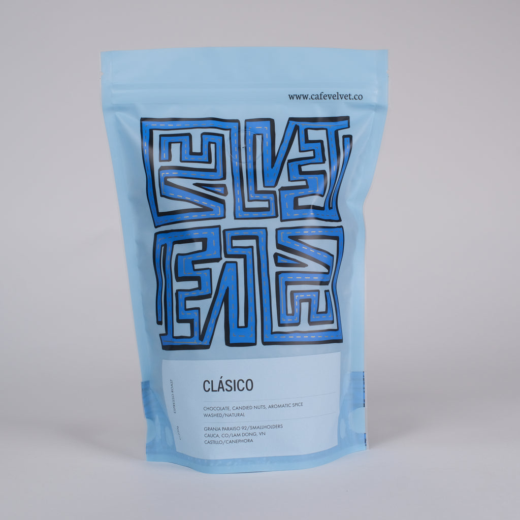 Blue coffee bag with 'Cafe Velvet' branding on a light gray background