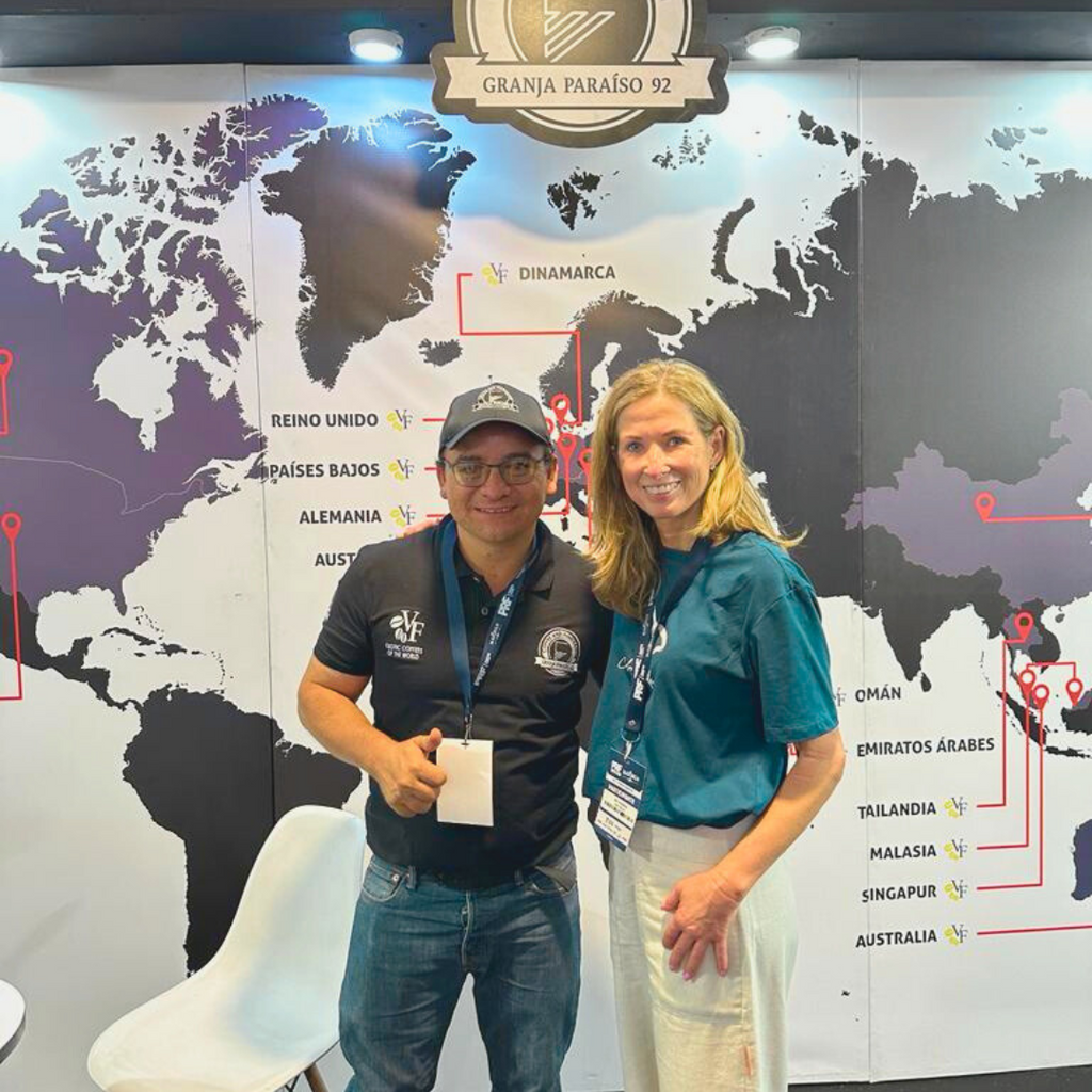 ilse and wilton benitez standing in front of a worldmap labeled granja paraiso 92 with various markings